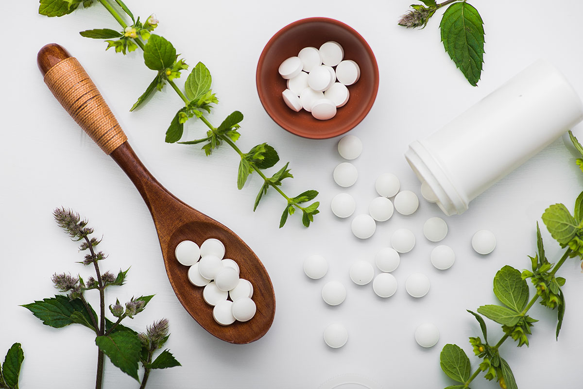 Health and wellness supplements, Fresh herbs with supplements on white background.