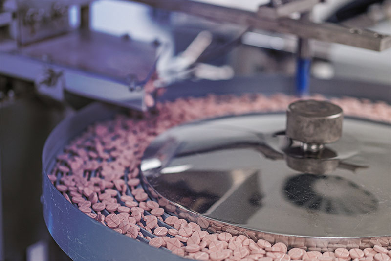 Macro shot of pills and capsules during production and packing process of modern supplement manufacturing factory. Tablet and Capsule manufacturing process. Macro shot of pills and capsules during production and packing process of modern supplement manufacturing factory. Tablet and Capsule manufacturing process.