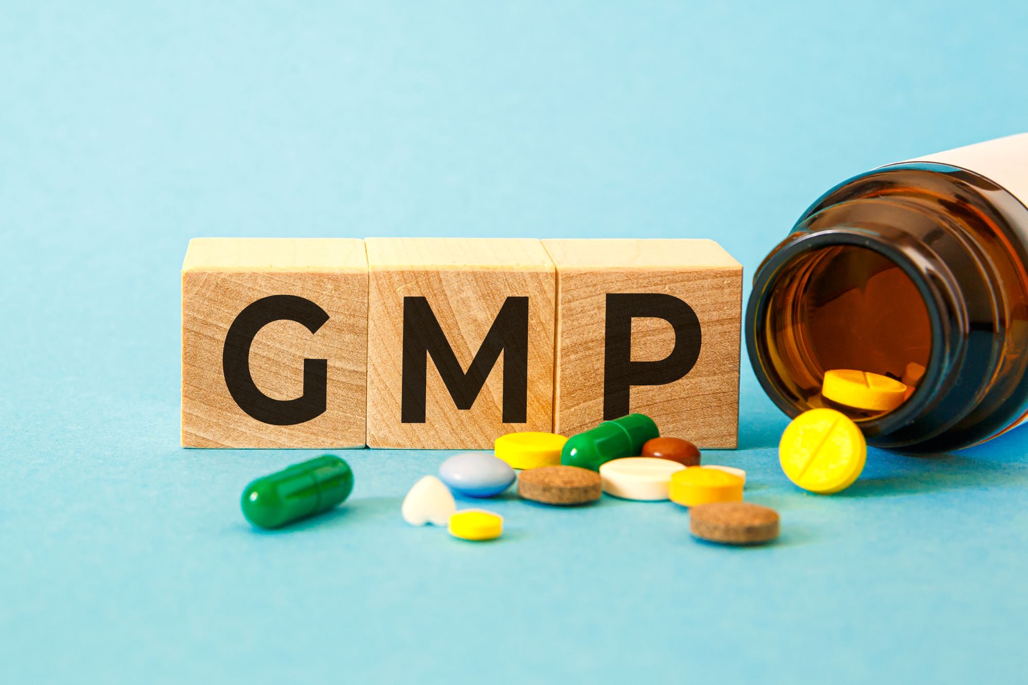 GMP Good Manufacturing Practice inscription on wooden cubes