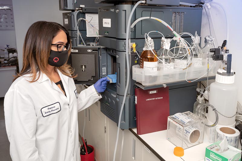 Scientist at Vitaquest performing quality assurance in a lab with advanced analytical equipment.